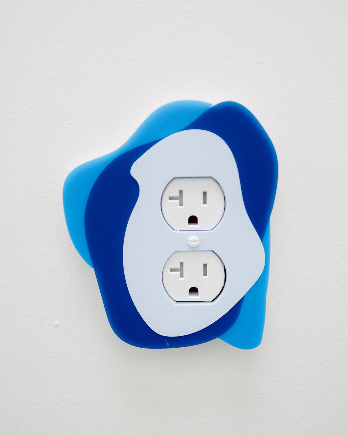 AALVO custom brand signage. Layered blue acrylic wall art framing an electrical outlet as a custom branded installation.