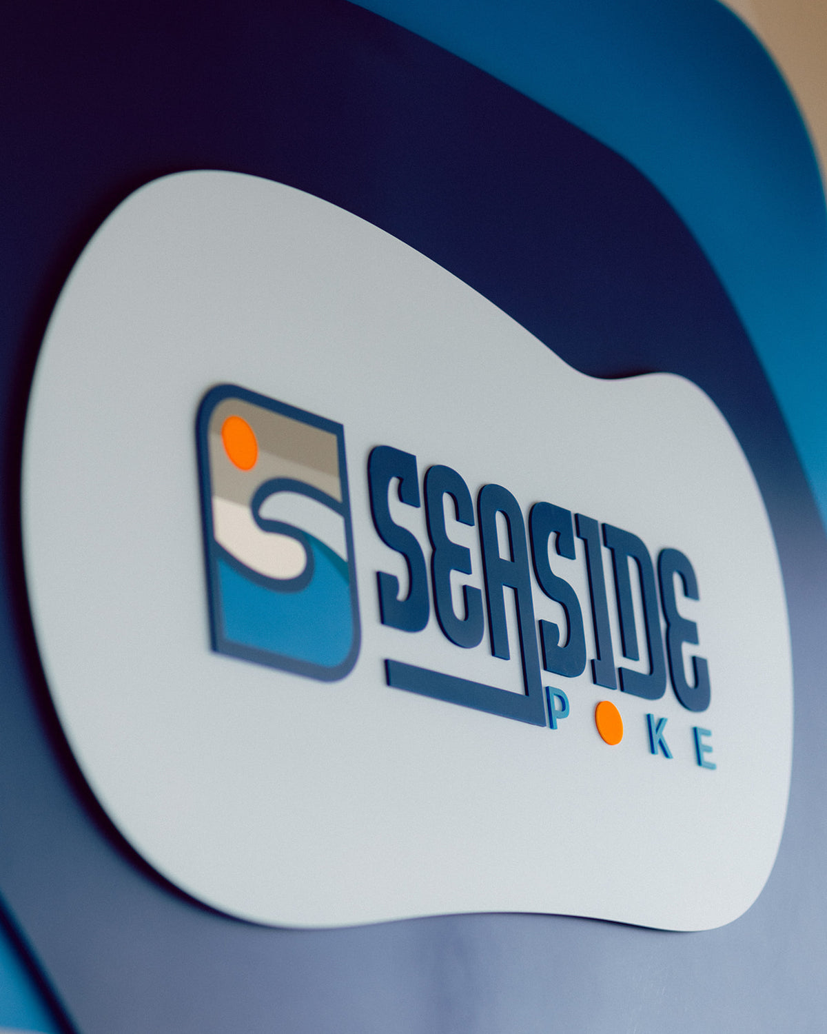 AALVO custom brand signage. Seaside Poke wall sign with blue wave logo and orange accent dots.