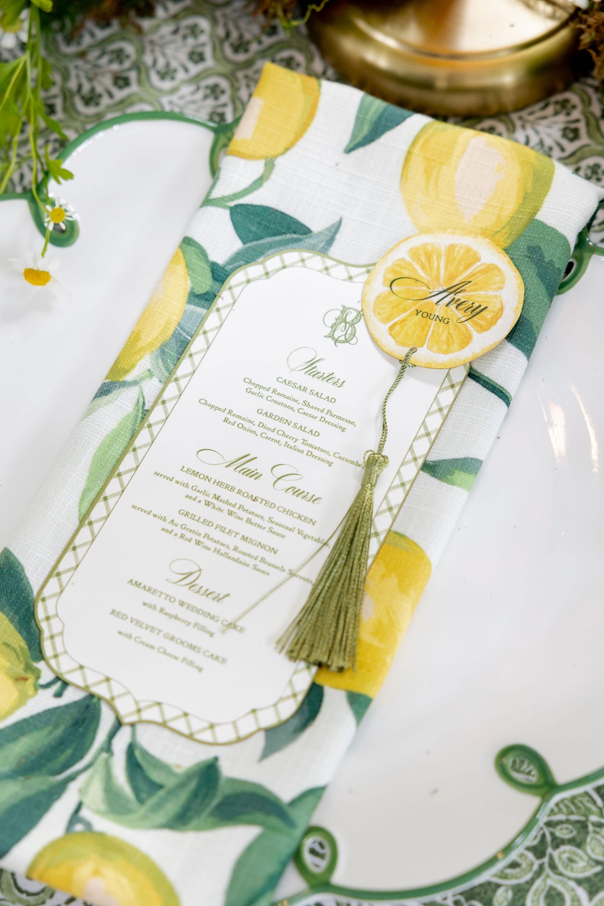AALVO custom wedding menu. Lemon-print wedding menu card with citrus-slice place card and tassel on a floral table setting.