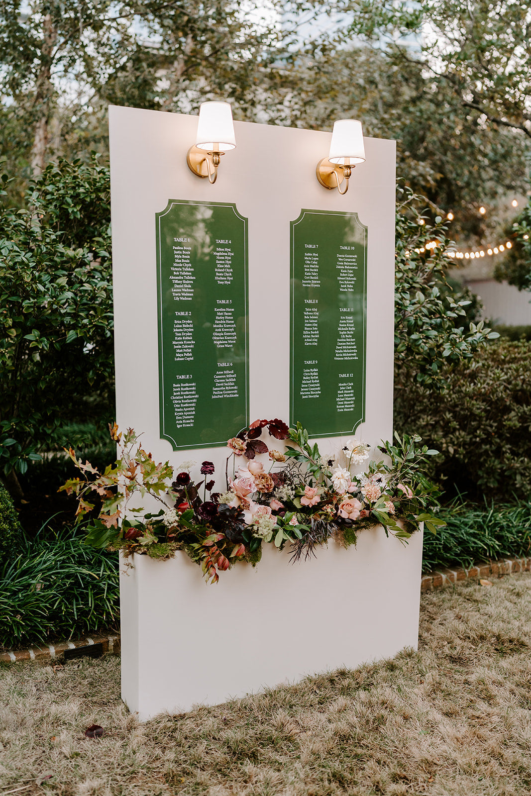 AALVO custom wedding signage. Decorative seating chart with floral arrangements outdoors for a wedding.