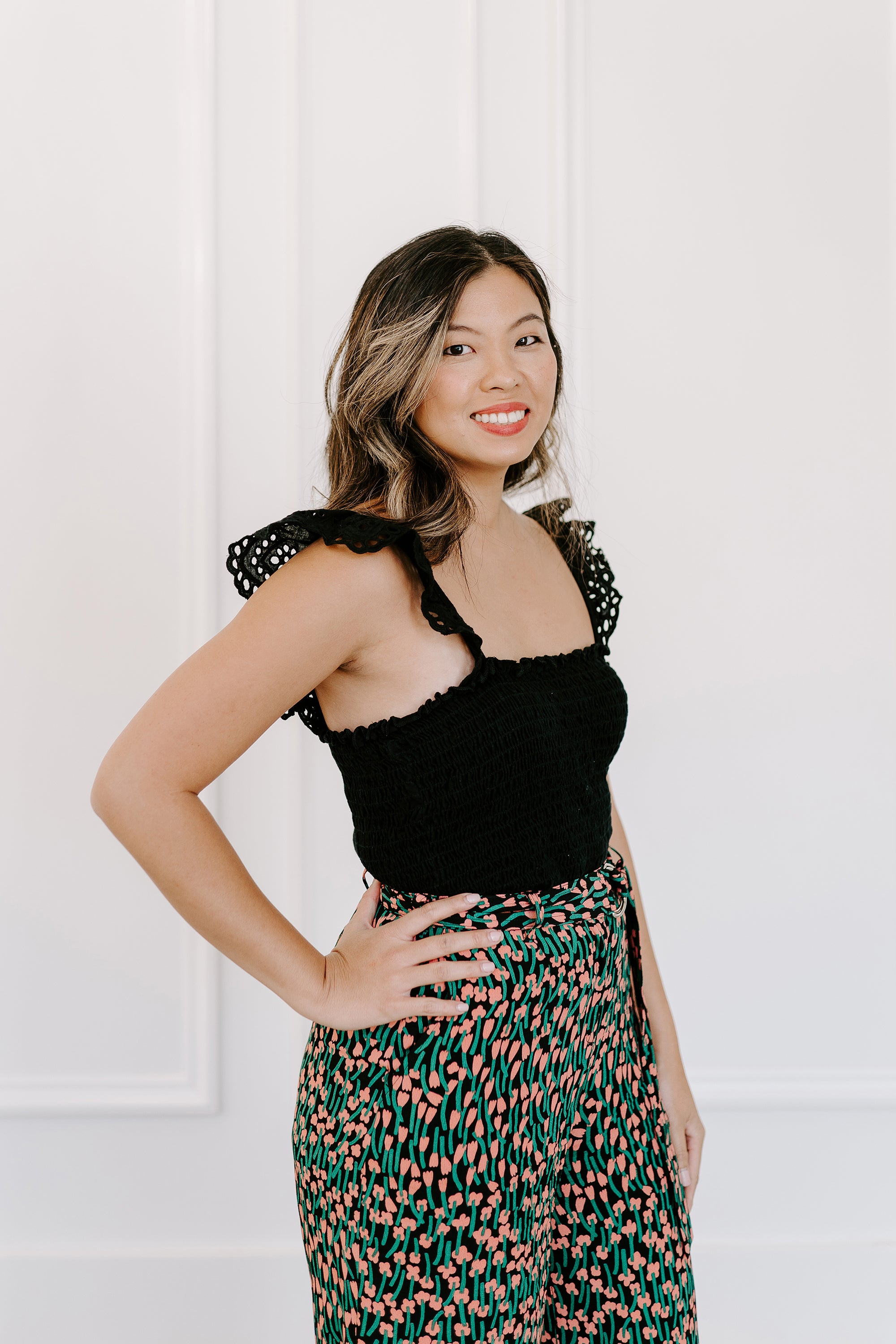 AALVO owner and designer. Asian woman in stylish clothes standing in front of a cream wall.