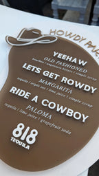 Brown acrylic with beige and white text. Cowboy hat accent and western font