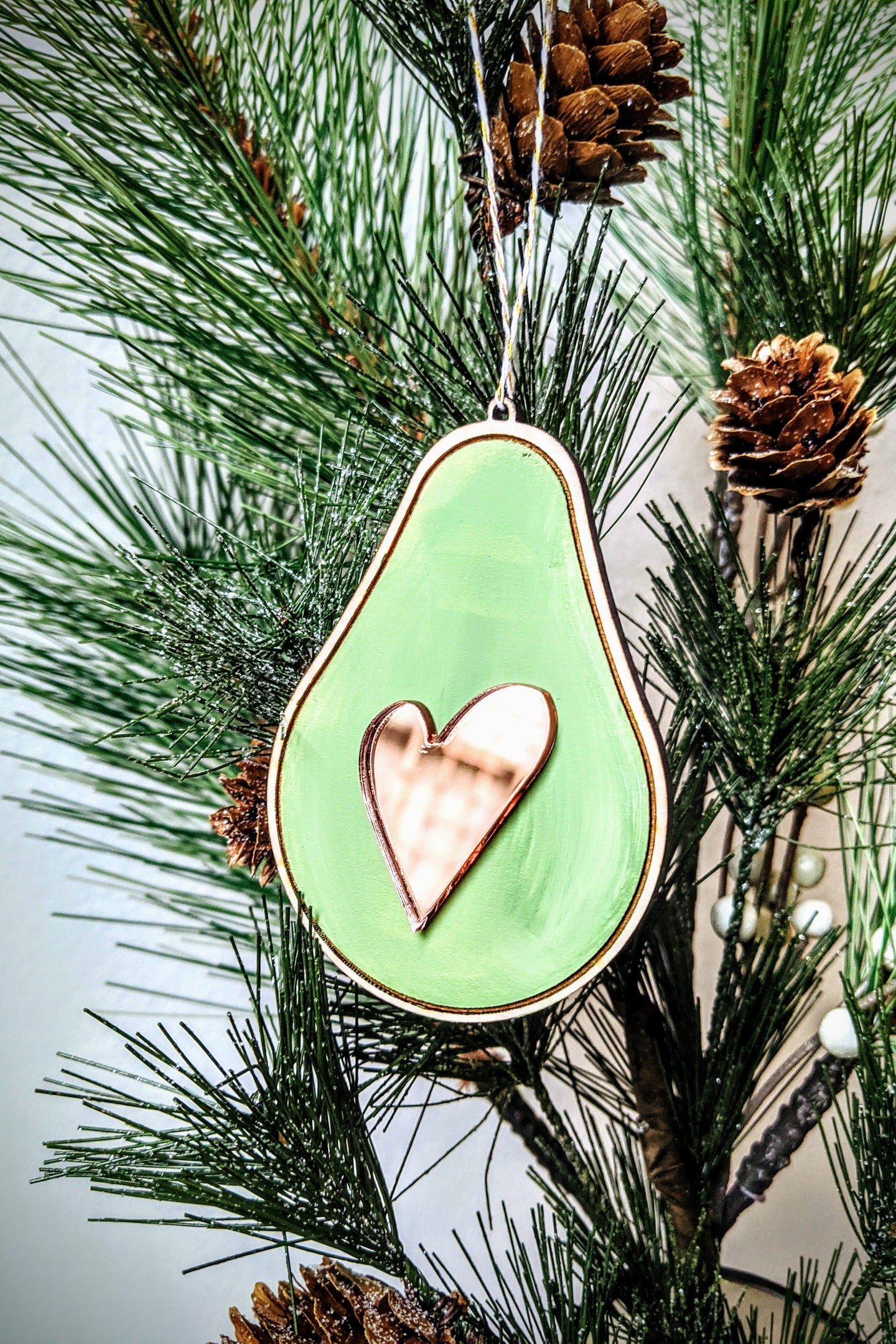 Avocado Christmas Ornament made from Birch Plywood with a mirrored pink acrylic heart as the pit